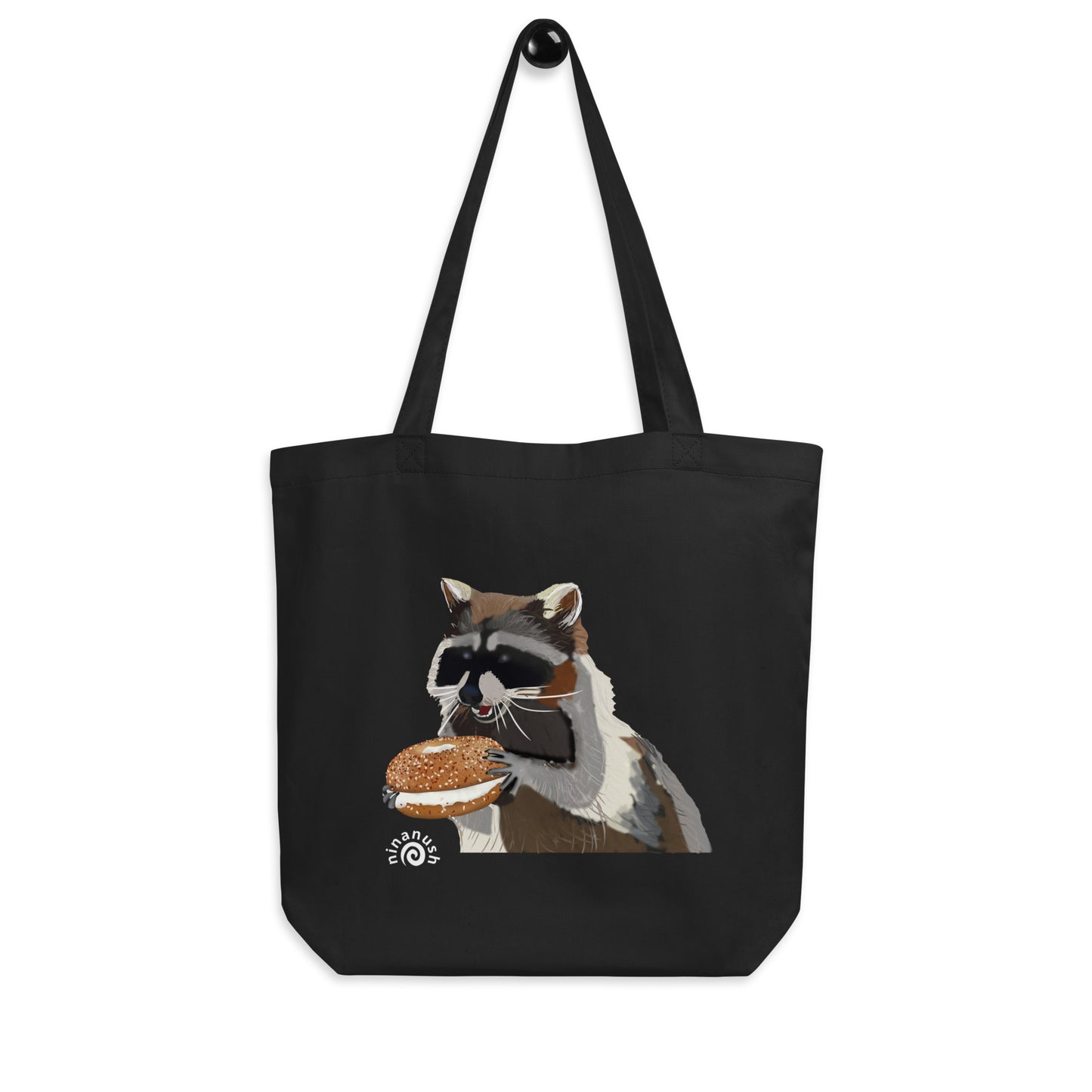 Black tote bag with raccoon and everything bagel - This everything bagel tote bag with a raccoon eating bagel is perfect for bagel lovers, foodies and raccoon enthusiasts. The funny foodie design is totally unique and the organic cotton tote bag is perfect for everyday adventures. Carry your groceries, bagels, books and everything in between in this sustainable shopping tote bag.