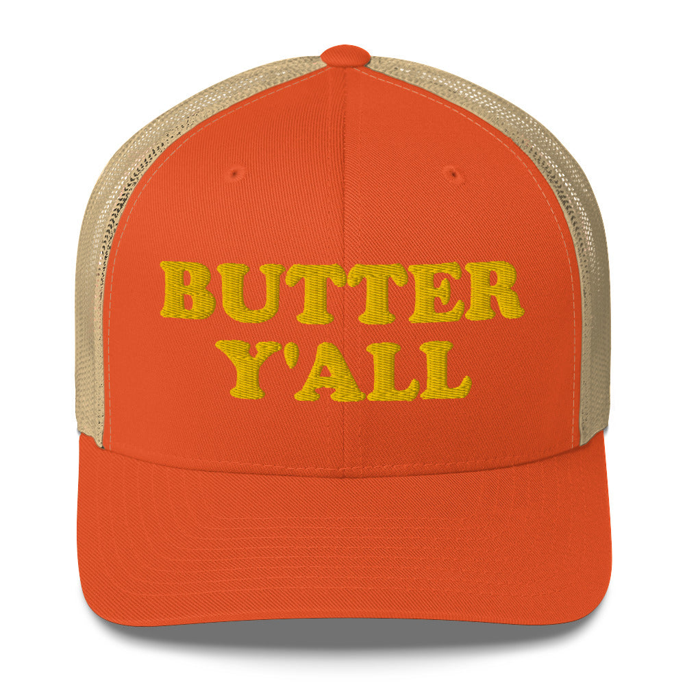 Orange and khaki Butter Hat - Are you a butter enthusiast? Looking for a funny gift? Our Butter Y'all Hat is comfortable and made just for you. It comes in a variety of colors with a funny butter phrase, expertly embroidered on the front. Make a statement and eat your favorite buttery foods in our butter y'all trucker hat. Edit alt text