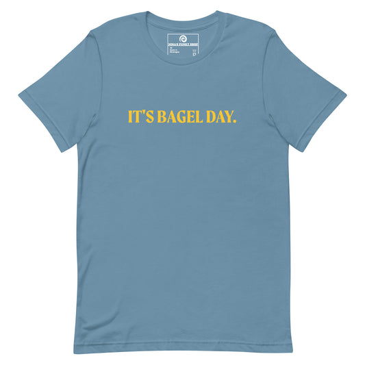 Steel Blue It's Bagel Day T-Shirt - Are you a bagel enthusiast? Looking for a funny gift for a fellow bagel lover? Every day is bagel day in our "It's Bagel Day T-shirt". It's a soft and comfortable, unisex t-shirt that comes in a variety of colors with a funny bagel saying, expertly printed on the front. Eat your favorite bagels and make a statement. Celebrate your favorite foods in our funky foodie apparel.