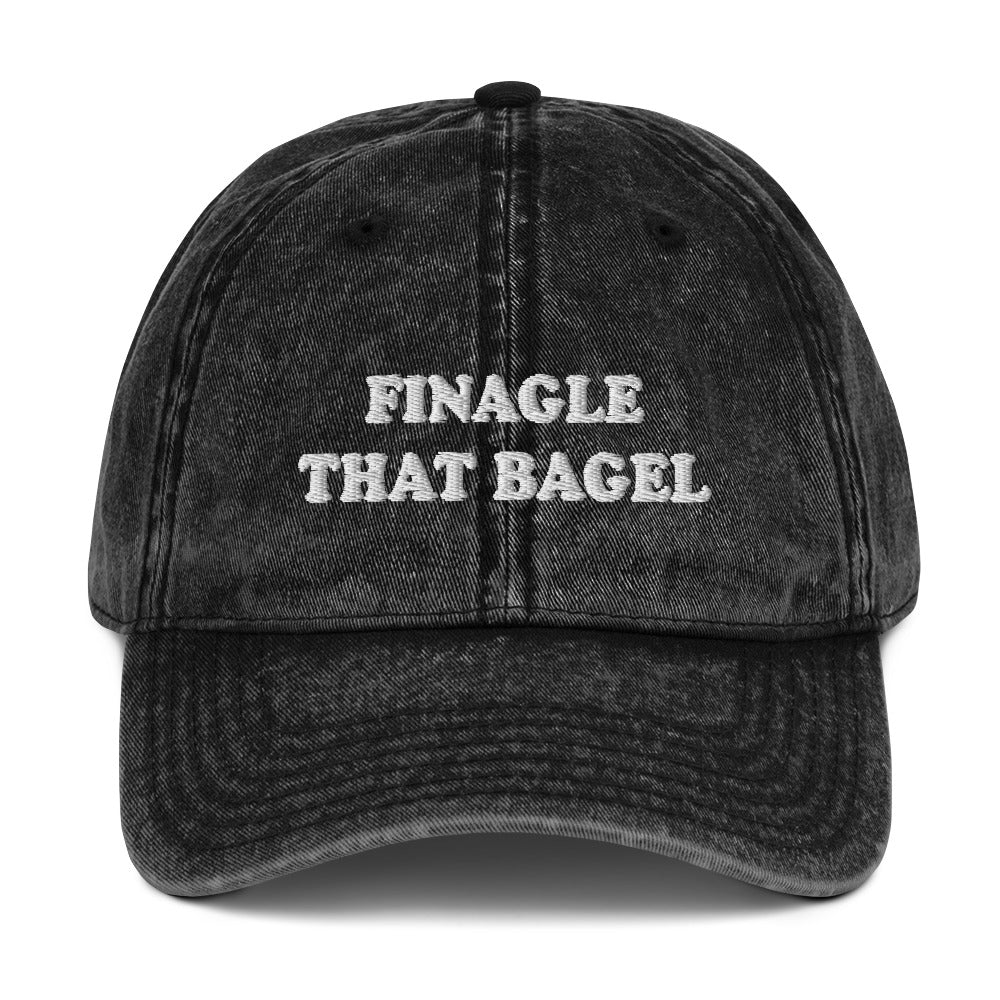 Black Finagle That Bagel Hat - Love Bagels? Looking for a funny gift for a bagel enthusiast? This Unique Bagel Hat is just what you need. It's comfortable, has an adjustable closure, and comes in a variety of colors with "Finagle That Bagel", on the front. Eat your favorite bagels in this funny food dad hat. Perfect for bagel lovers and beyond.