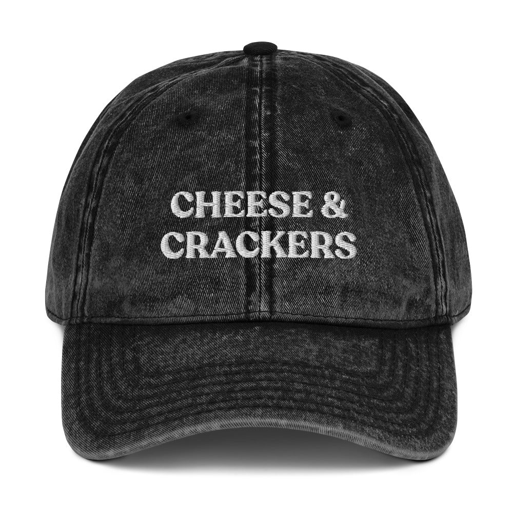 Black cheese and crackers hat - Our Cheese & Crackers Hat is made of comfortable cotton and expertly embroidered just for you. It's a classic dad hat that's perfect for everyday streetwear that will have people asking "Where'd you get that hat?" Make a statement in this funny foodie dad hat.